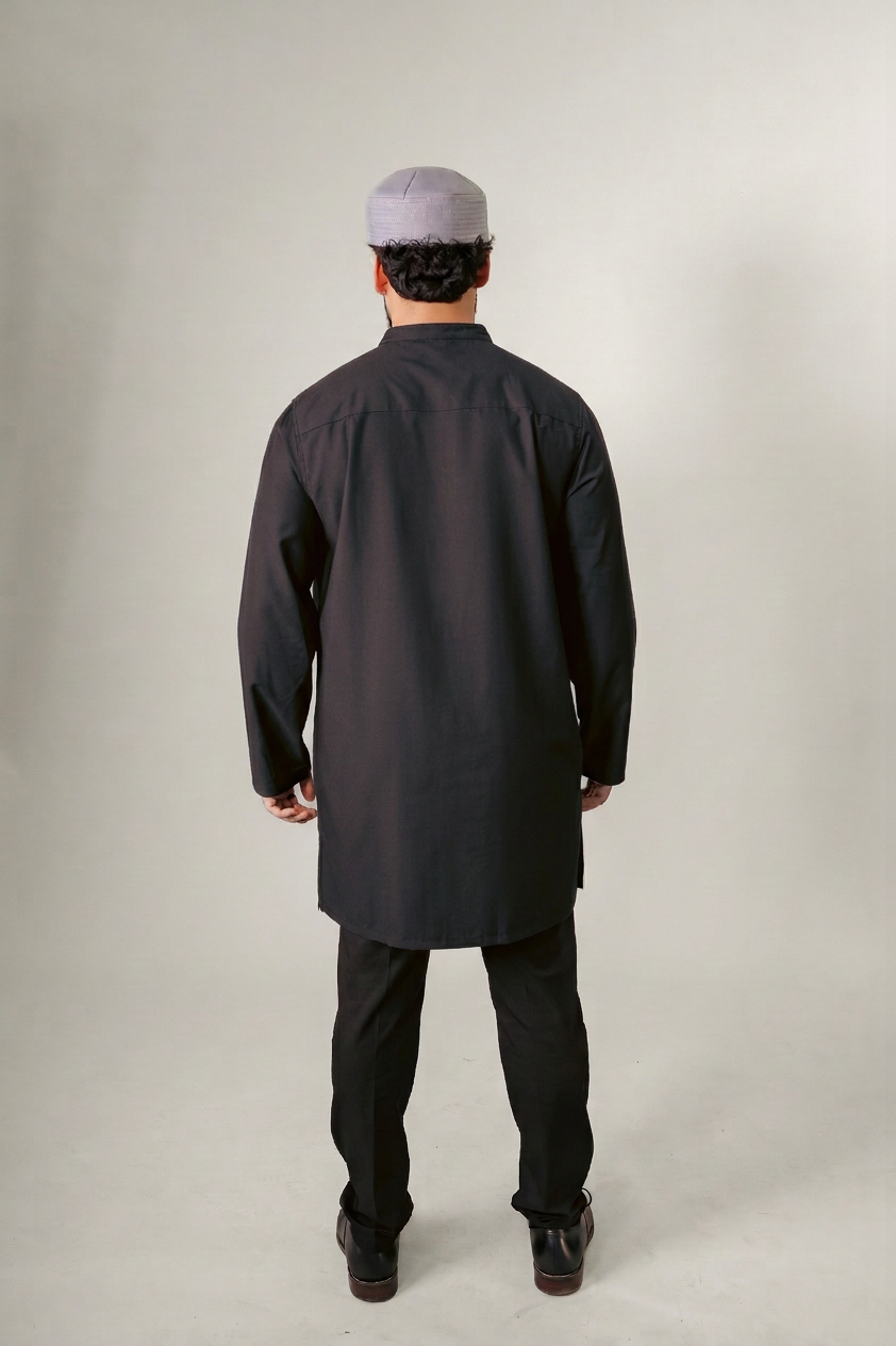 Man in a blue hooded robe holding glasses and a black bag against a white background.