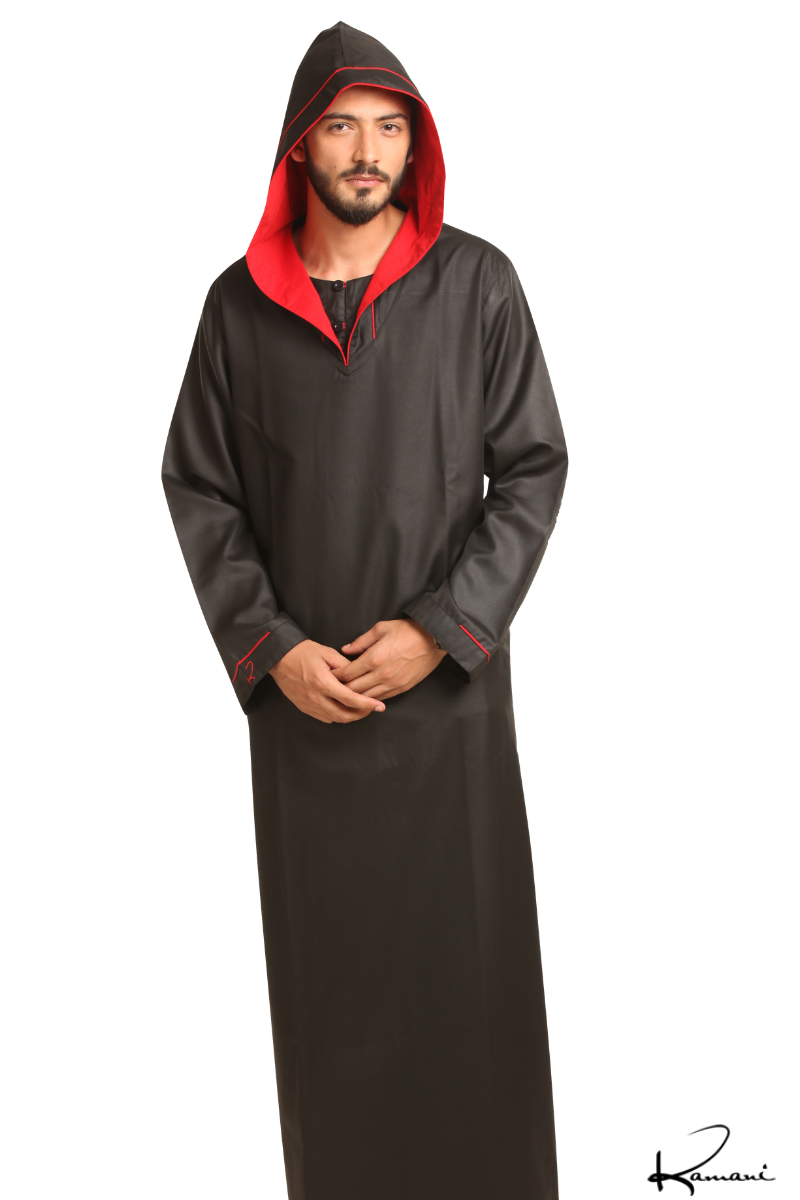 A person in a dark hooded robe, holding a string of beads, standing with back turned.
