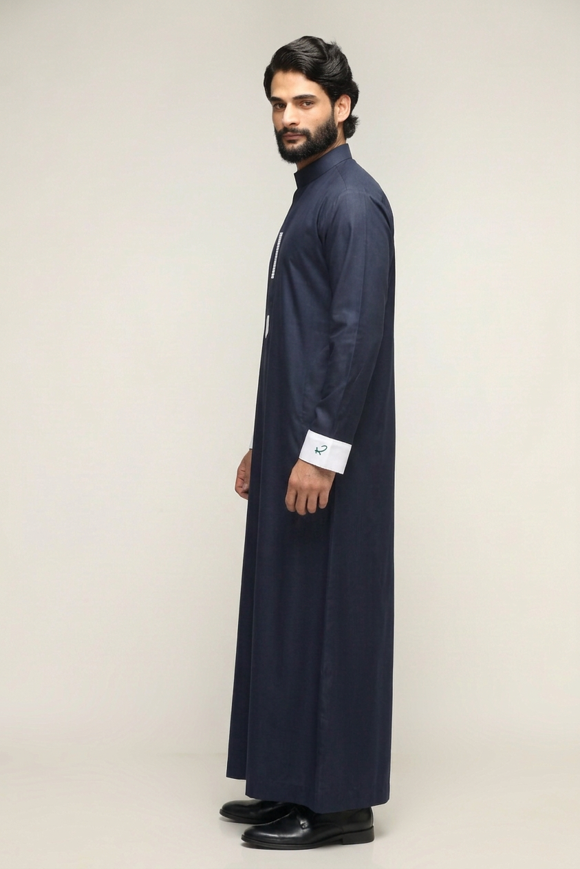 Man in a blue hooded robe holding glasses and a black bag against a white background.